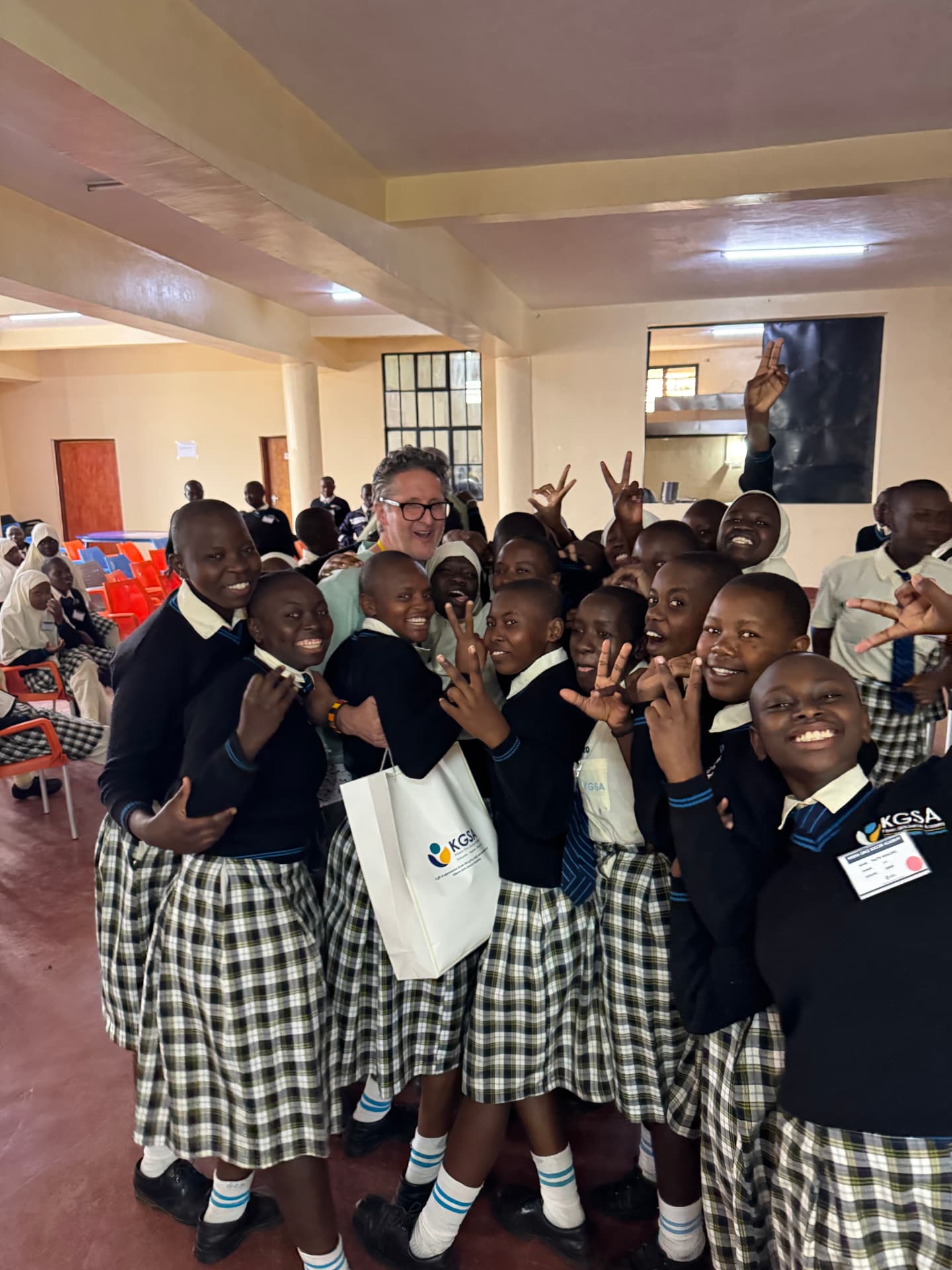 KGSA students celebrating with a visiting supporter in the school hall