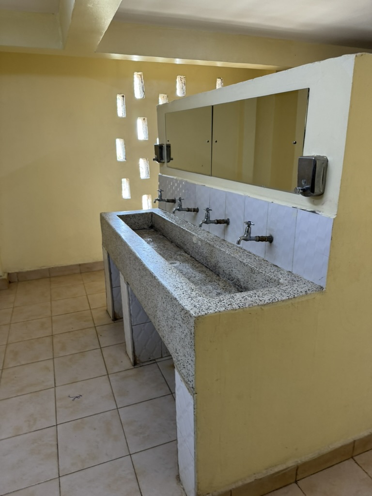 A clean shared washroom with a long stone sink at the KGSA campus